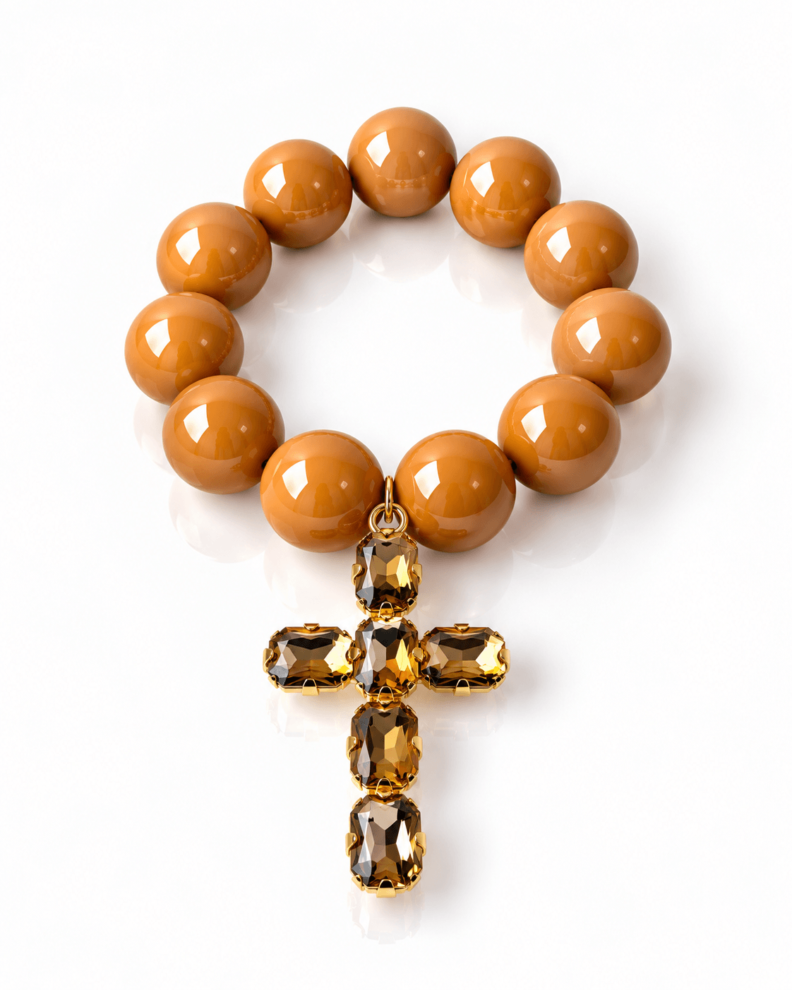 The Grand Cross Armband mit großen glänzenden Resin-Perlen in warmem Caramel Cognac und Kreuzanhänger mit facettierten Kristallsteinen in Cognac.