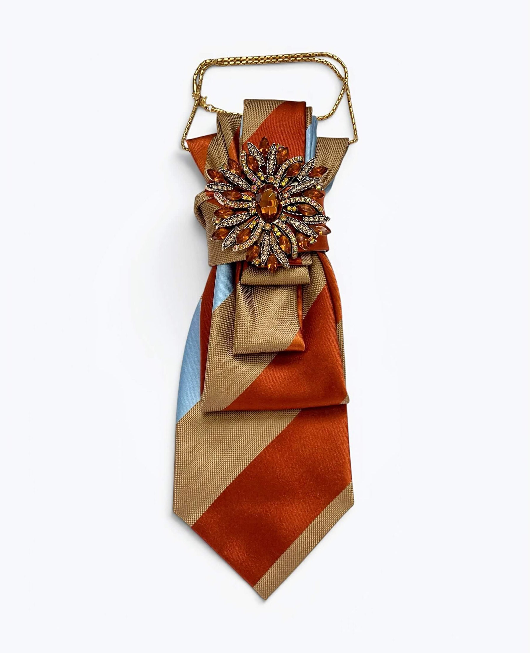 Vintage-Krawatte in Camel, Orange und Hellblau mit diagonalen Farbflächen, dekorativer Schmuckbrosche in Bernsteinoptik und goldfarbener Kette.